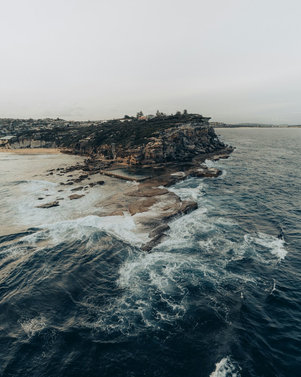 ocean waves crashing on brown rock formation during daytime