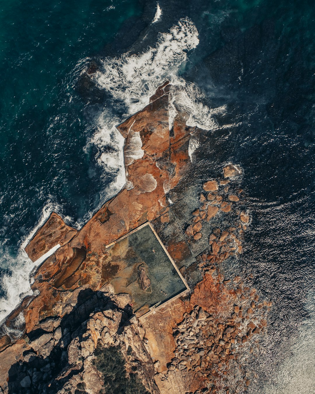 aerial view of brown and gray concrete road beside body of water during daytime