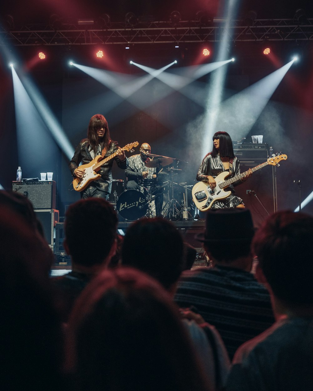 uomo in camicia nera che suona la chitarra sul palco