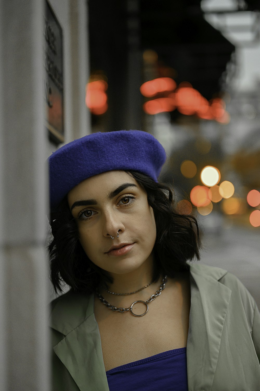 woman in white dress shirt wearing blue knit cap