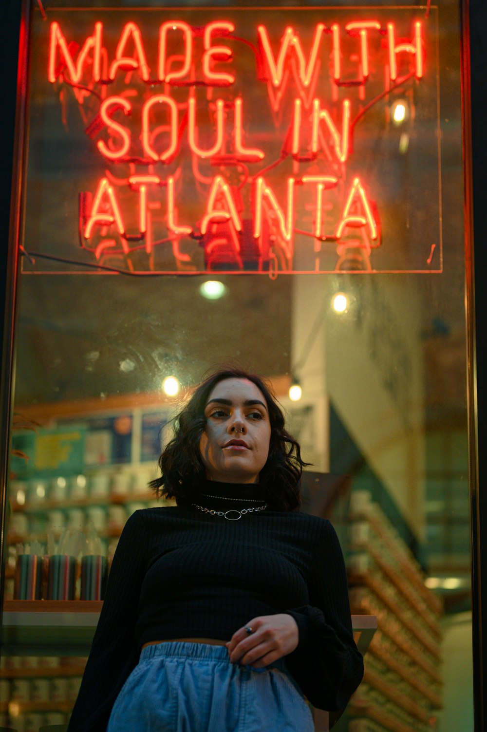 woman in black turtleneck sweater standing beside glass window
