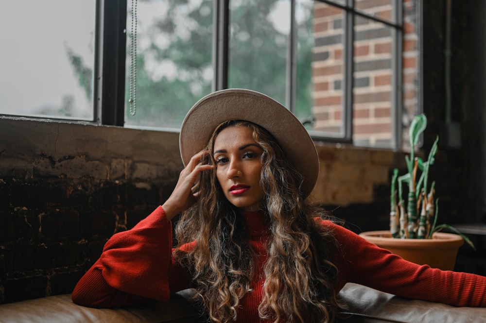 woman in red long sleeve shirt wearing brown hat