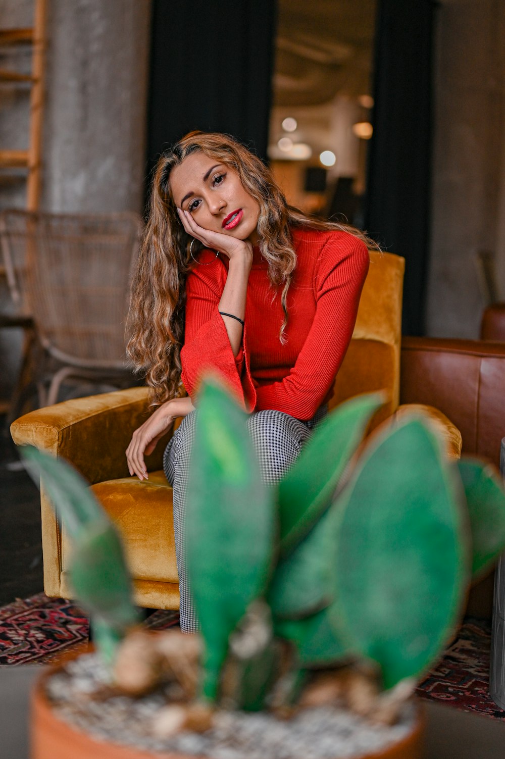 woman in red blazer sitting on brown wooden armchair