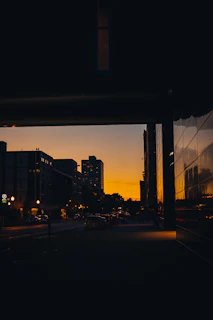 An urban scene at dusk with muted colors and reflective surfaces.