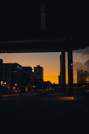 An urban scene at dusk with muted colors and reflective surfaces.