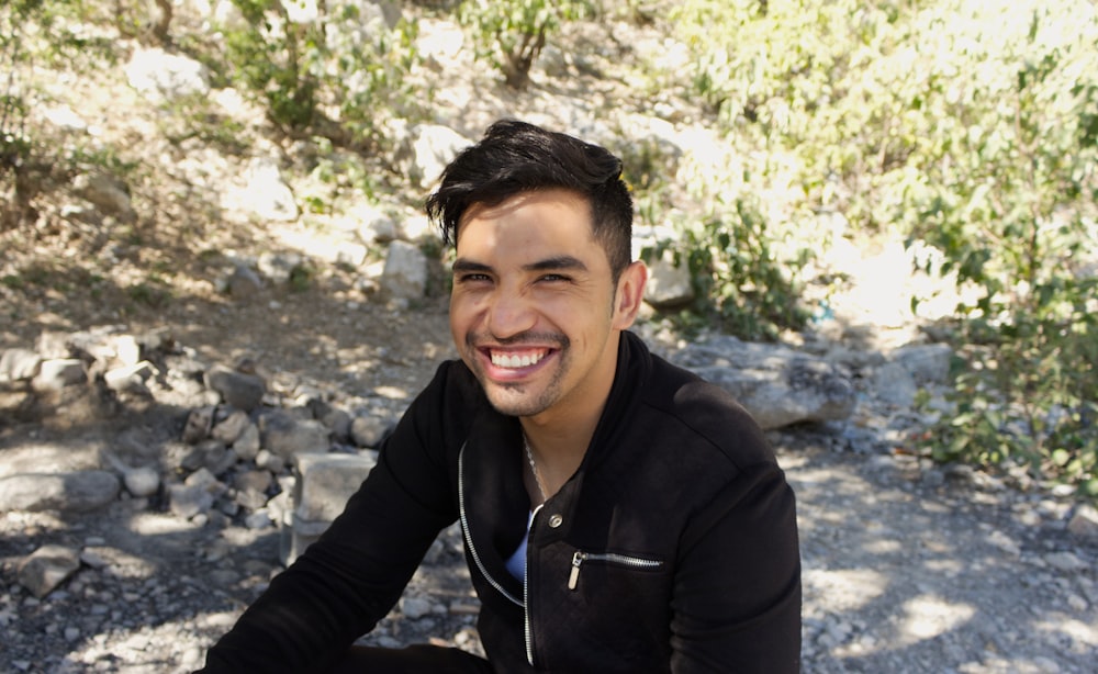 man in black zip up jacket smiling