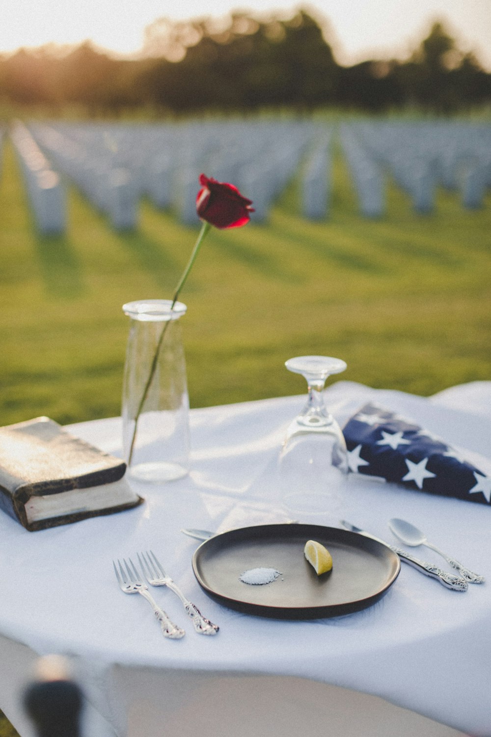 stainless steel fork on white ceramic plate beside clear wine glass on white table cloth