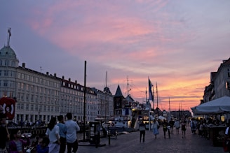 Tourists enjoying a sunset ride along the riverfront in a remorque, with the city skyline glowing behind them.