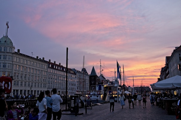 Tourists enjoying a sunset ride along the riverfront in a remorque, with the city skyline glowing behind them.