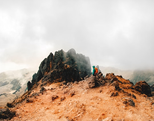 man in green jacket standing on brown soil under white cloudy sky during daytime in Popocatepetl Mexico