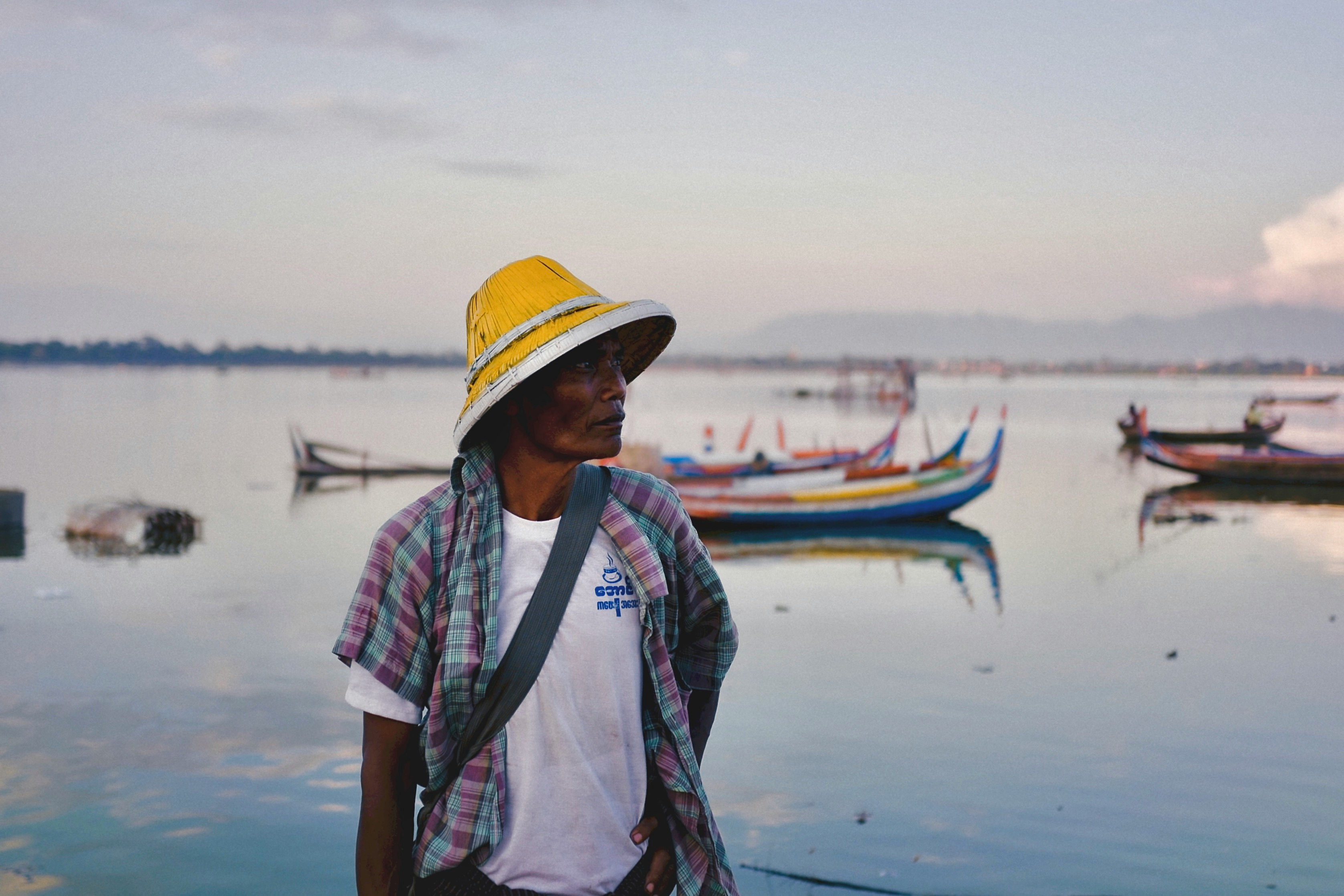 woman in white and blue stripe shirt wearing yellow fedora hat standing on beach during daytime