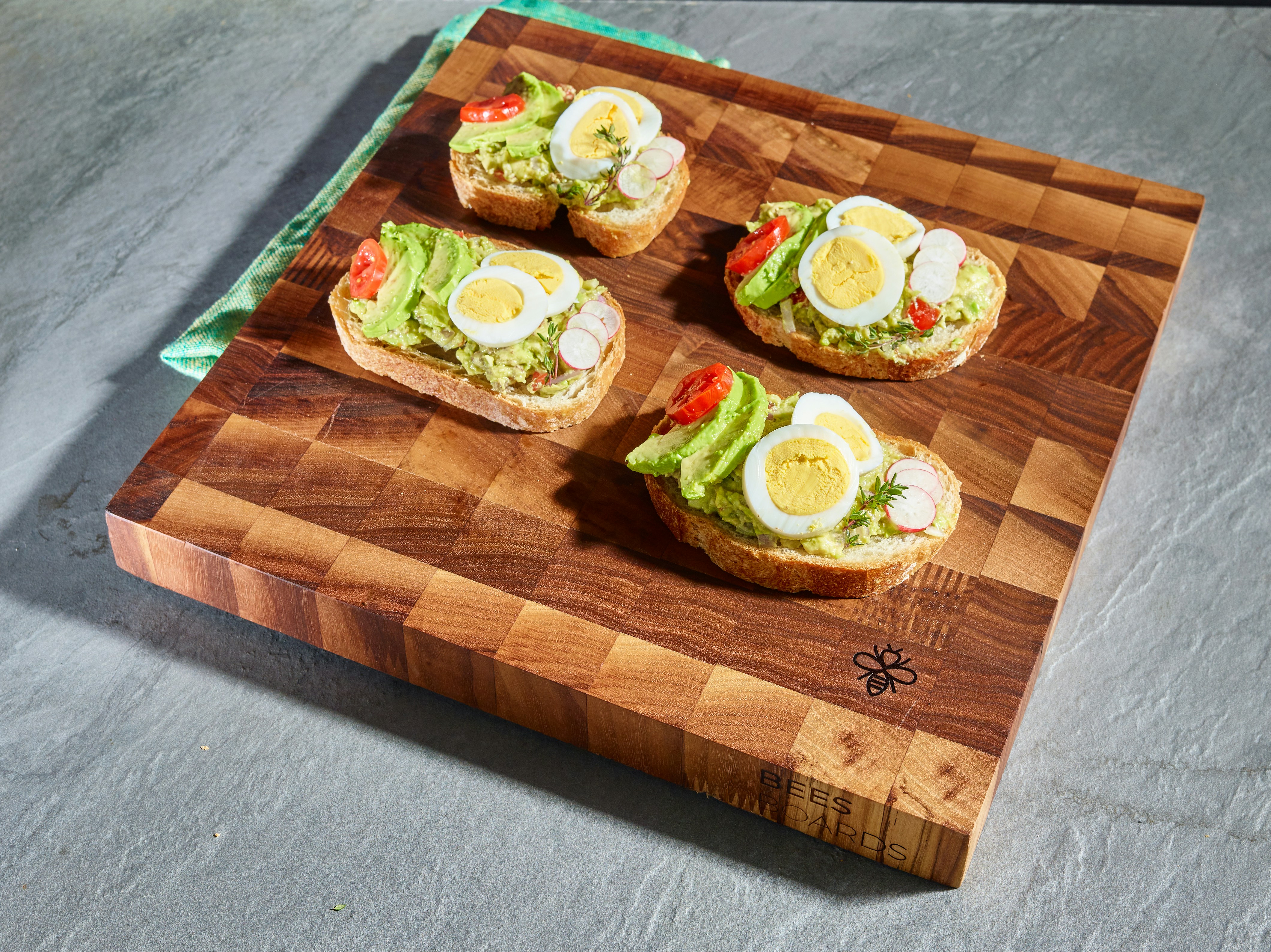 Egg and avocado toasts on a chopping board