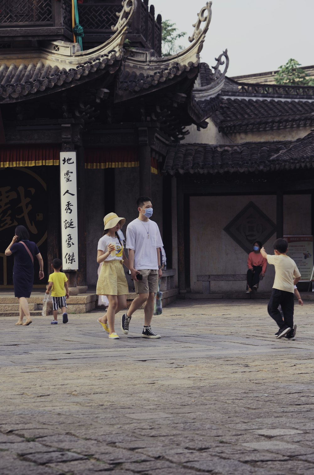 man in white dress shirt and yellow pants walking on street during daytime