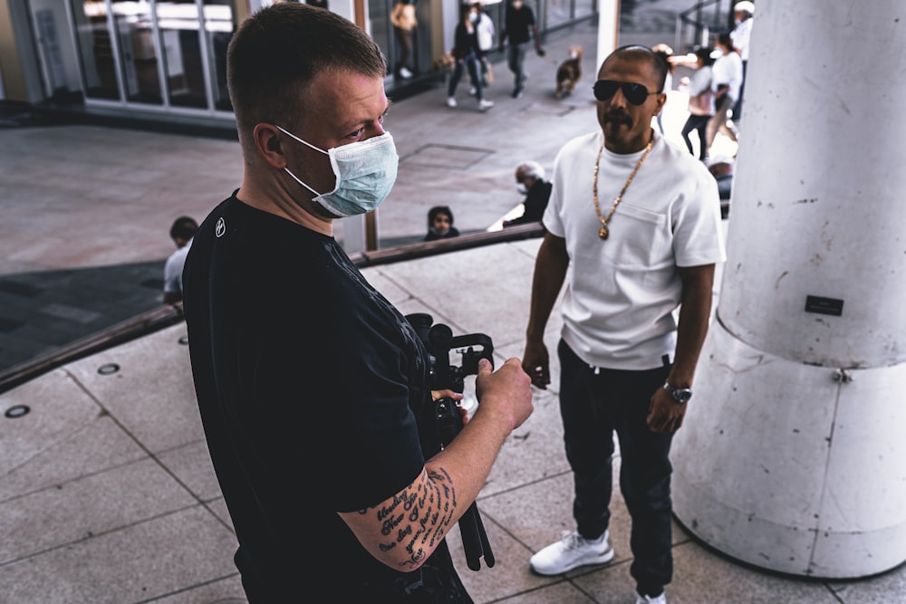 man in white crew neck t-shirt and black pants wearing white framed sunglasses