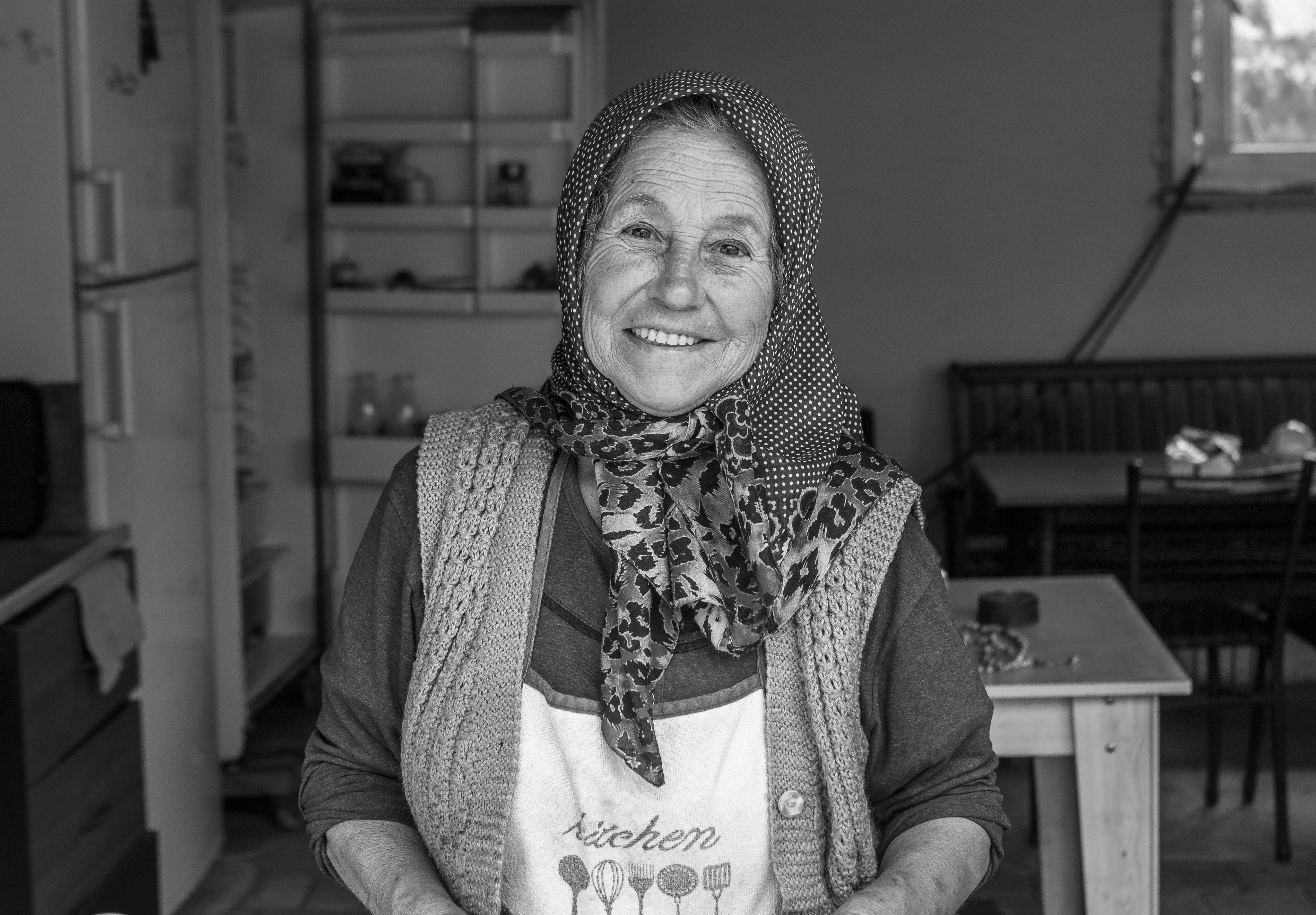 a black and white photo of a woman in a kitchen