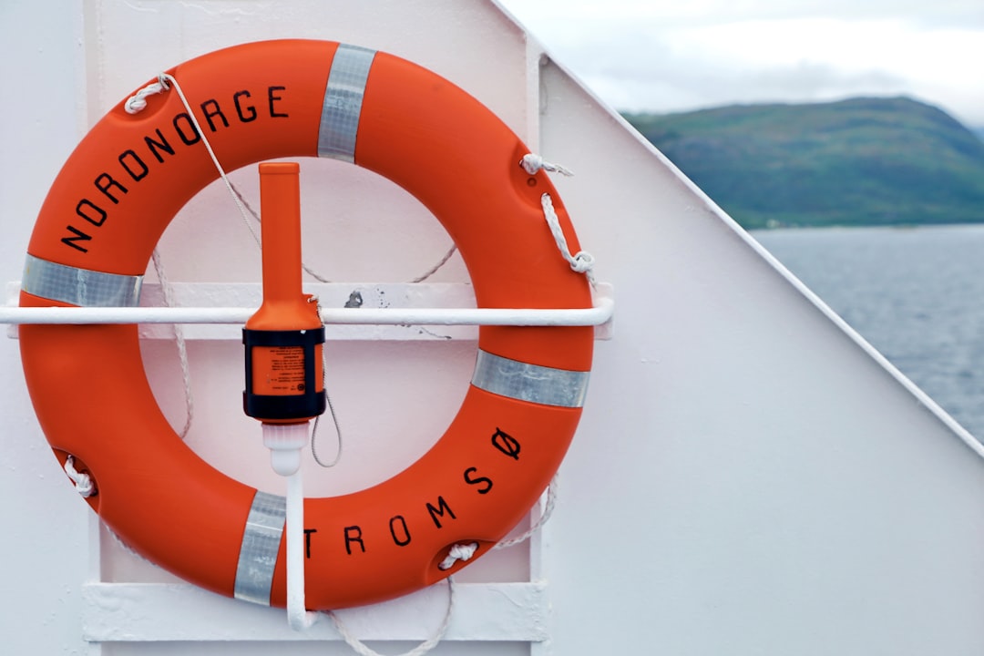 orange and white ship wheel, Life ring (rescue ring) of MS Nordnorge which is traveling along the coast of Norway.