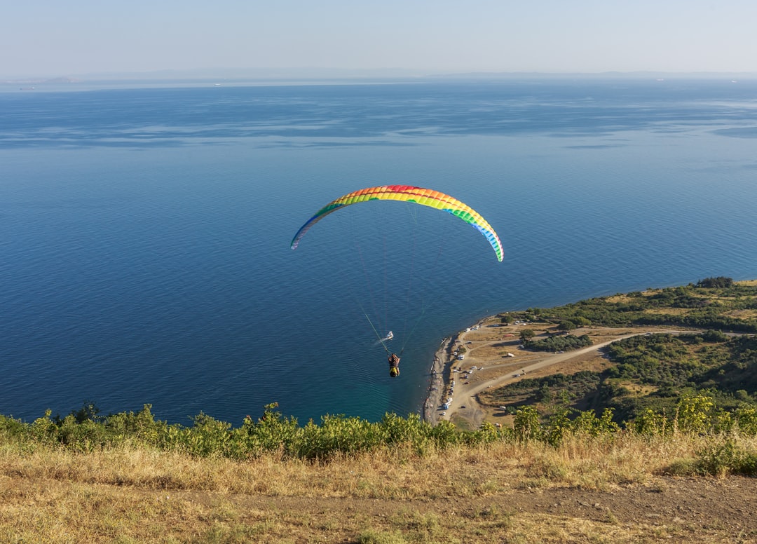 a paraglider is flying over a body of water,