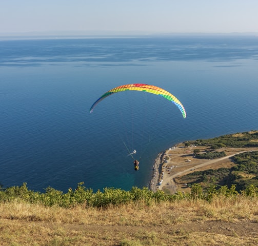 a paraglider is flying over a body of water