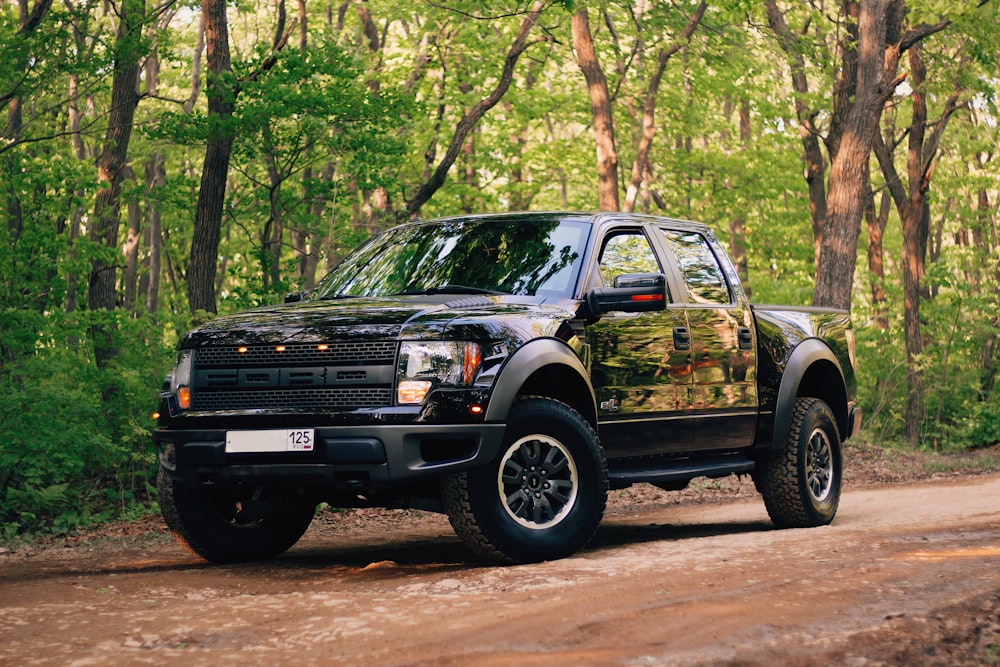 black and yellow chevrolet crew cab pickup truck parked on dirt road during daytime