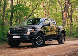 black and yellow chevrolet crew cab pickup truck parked on dirt road during daytime