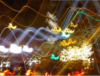 A collection of colorful, wavy light trails against a dark background, creating an abstract and dynamic visual pattern.