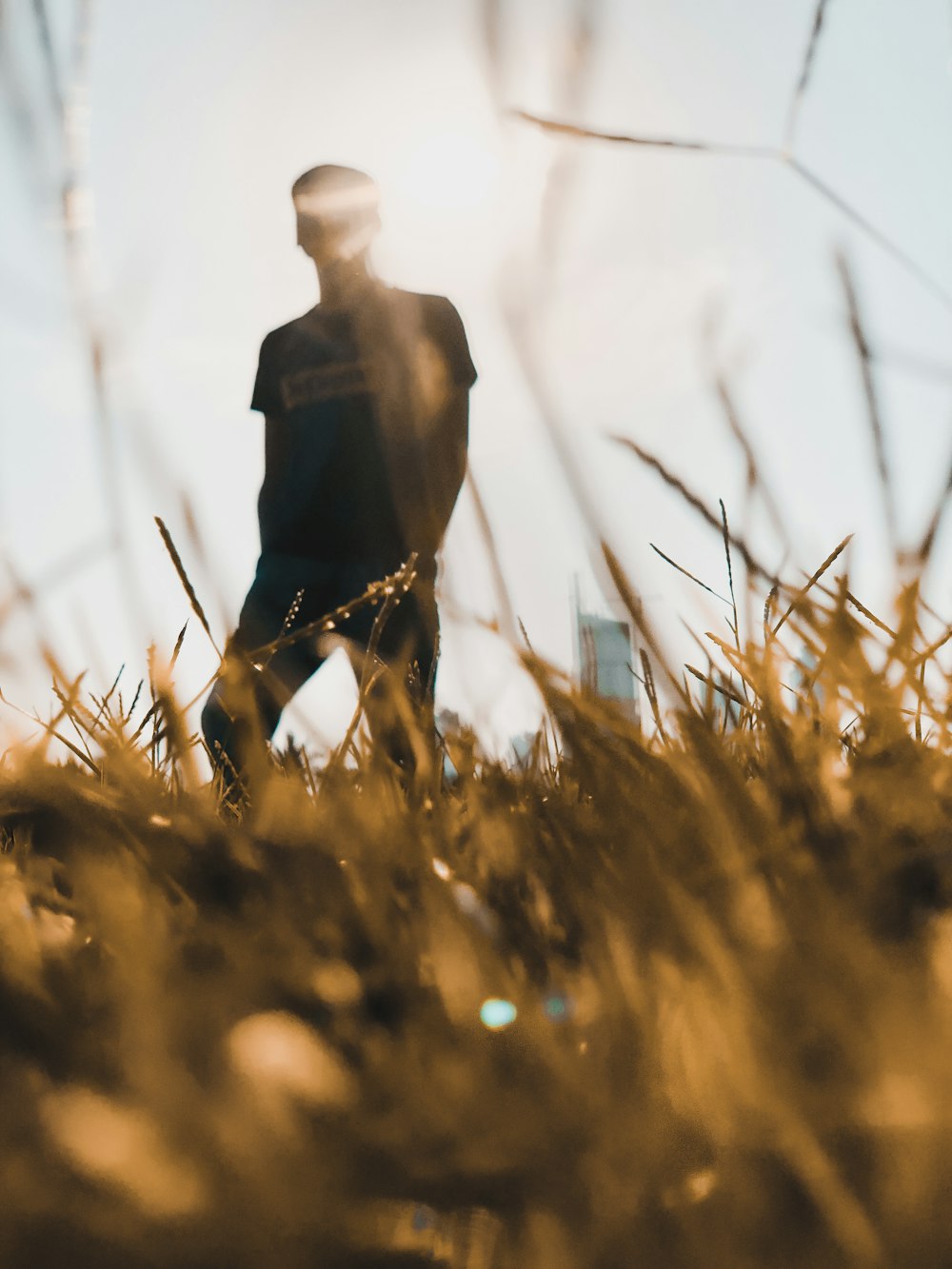 man in black coat walking on brown grass field during daytime