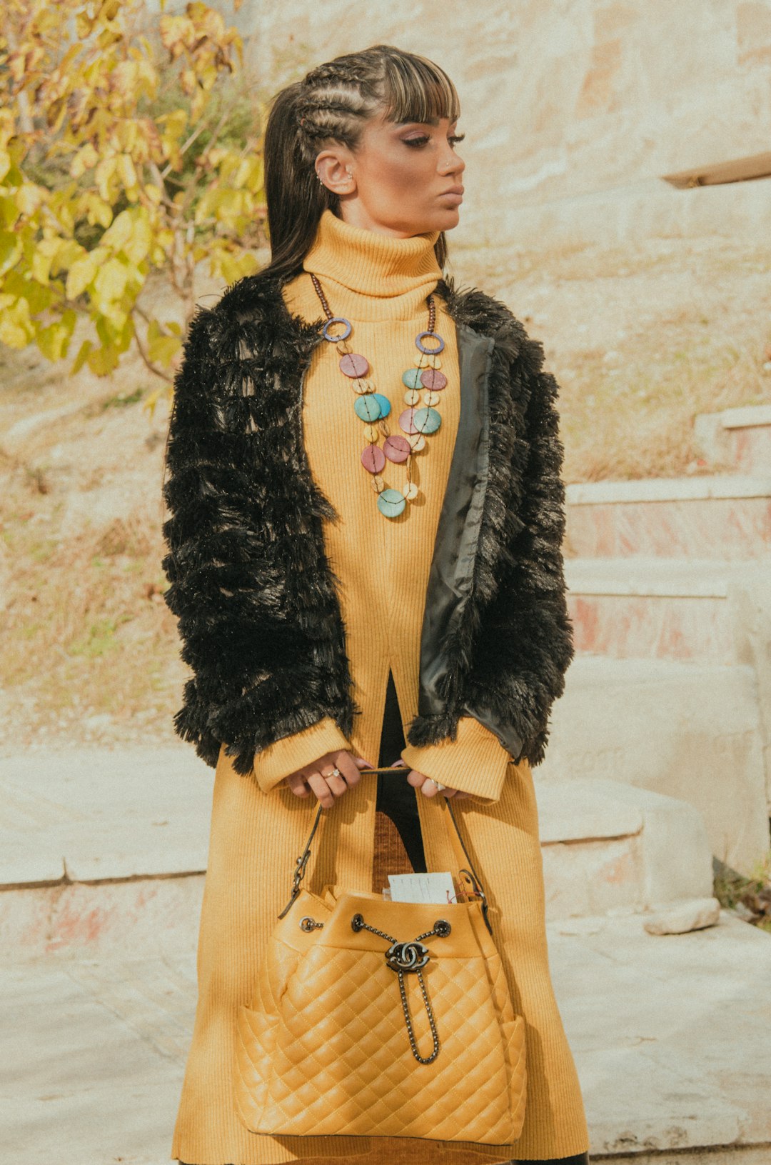 woman in black fur coat and brown sling bag