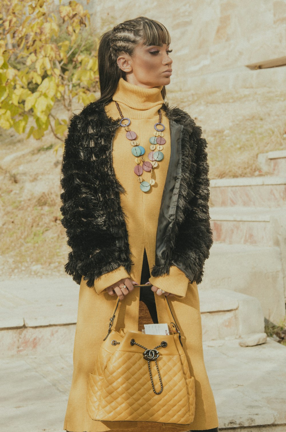 woman in black fur coat and brown sling bag