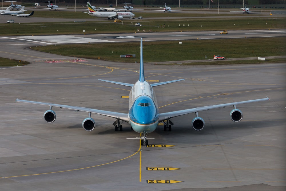 white and blue airplane on airport during daytime