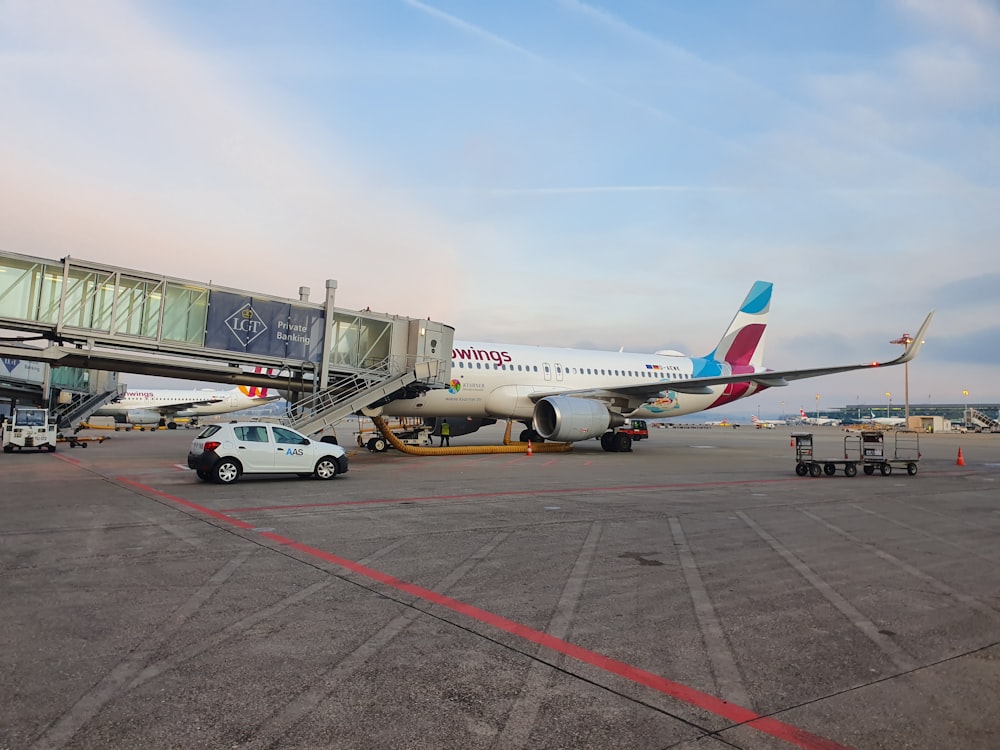 Avión de pasajeros blanco y azul en el aeropuerto durante el día