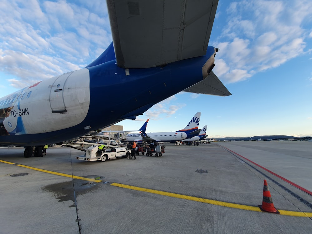 white and blue airplane on airport during daytime