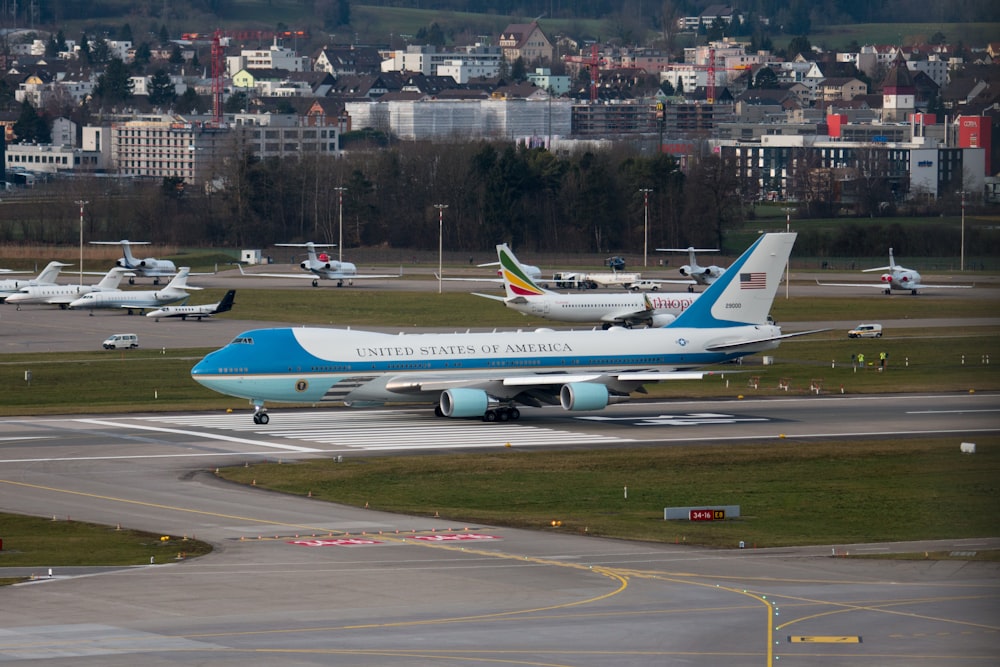 white and blue passenger plane on airport during daytime