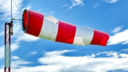 red and white flag under blue sky during daytime