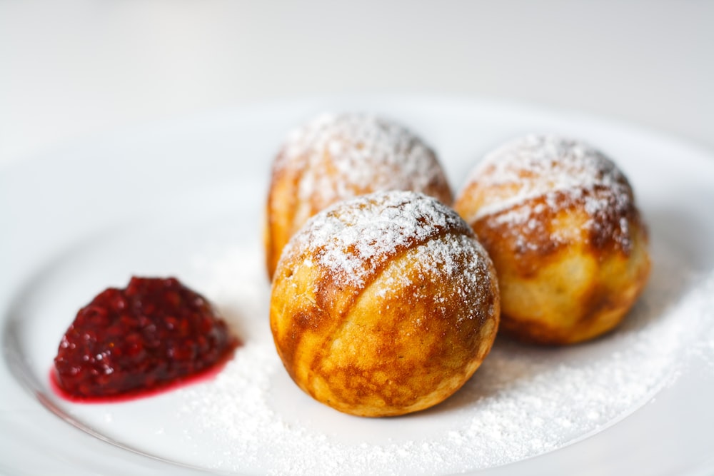 three brown round pastries on white ceramic plate