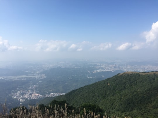 green mountains under blue sky during daytime in Shenzhen China