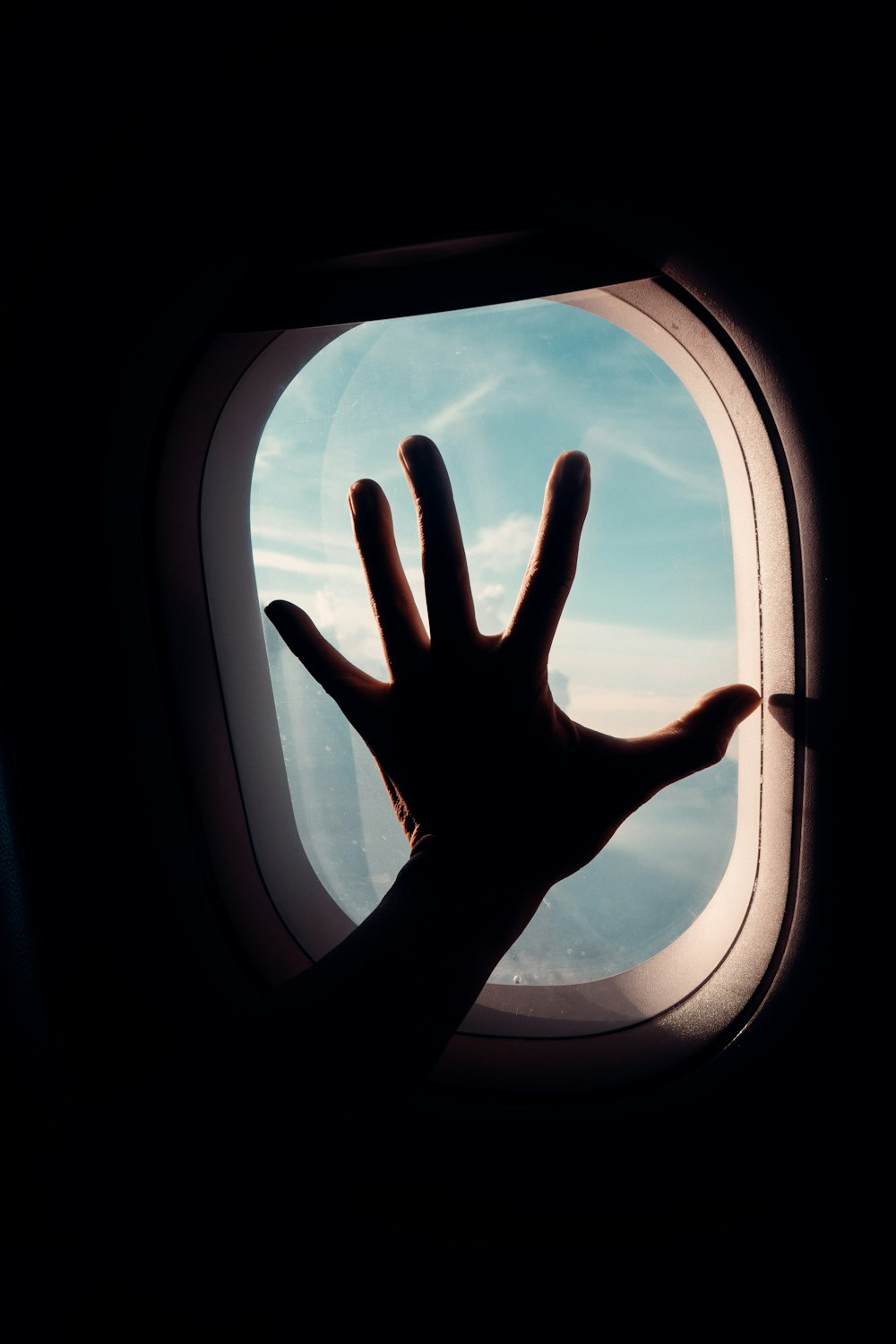 persons hand on airplane window