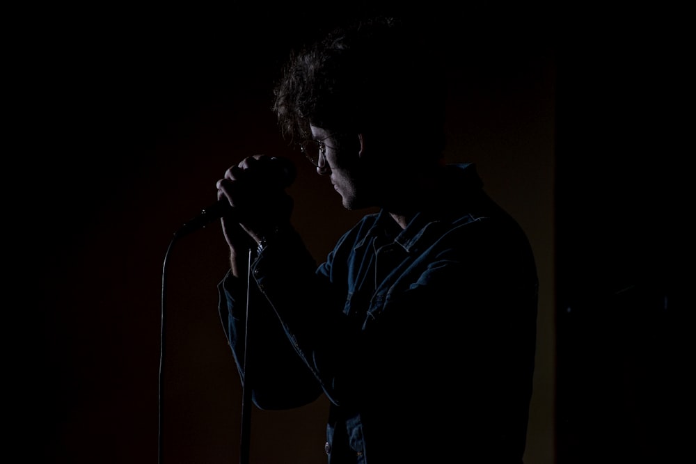 man in blue dress shirt singing