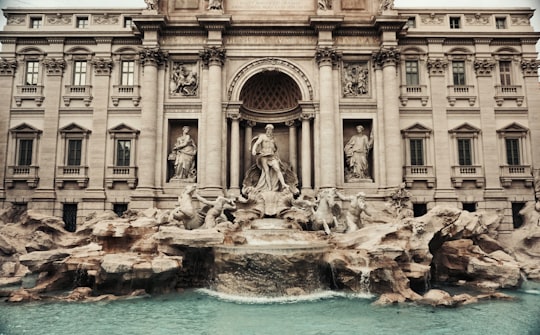 gray concrete building near body of water during daytime in Trevi Fountain Italy