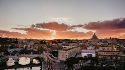 A panoramic view of the Bund with historic buildings lining the Huangpu River at sunset.