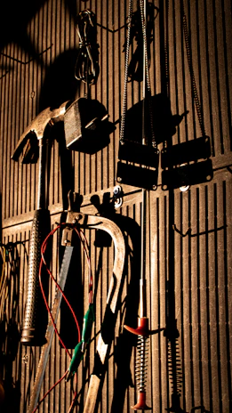 Suspension components hanging on a wall rack in the workshop with natural light.