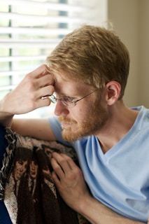 man in blue crew neck shirt wearing eyeglasses