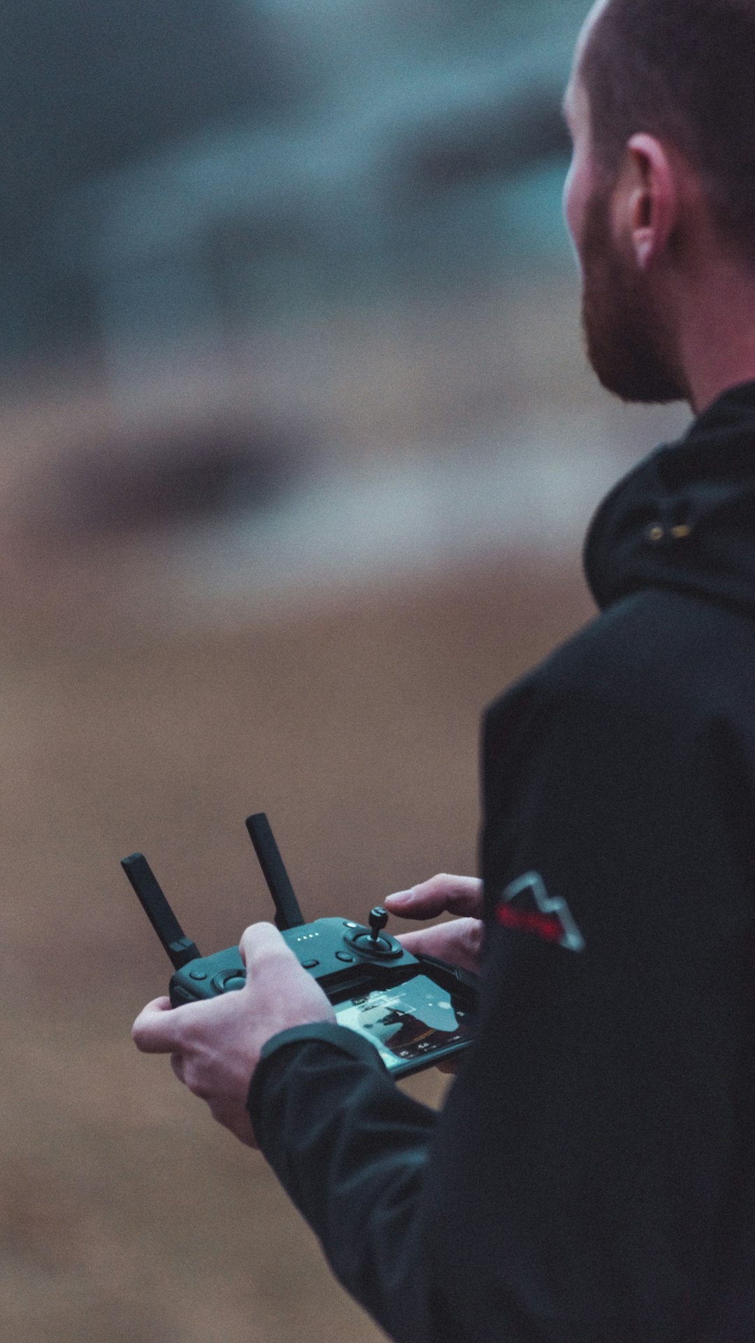 person in black jacket holding black smartphone