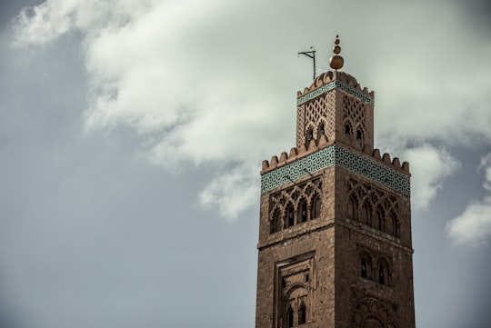 brown concrete building under white clouds during daytime in Koutoubia Mosque Morocco