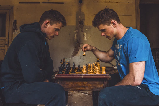 Players intensely focused during a chess match under warm lighting.