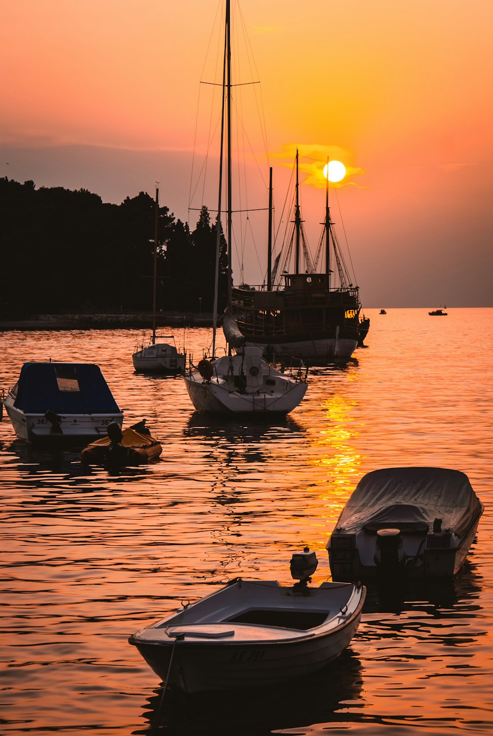 silhouette of boat on sea during sunset