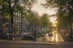 black bicycle on bridge over river during sunset
