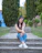 woman in blue denim jeans sitting on concrete pathway during daytime
