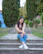woman in blue denim jeans sitting on concrete pathway during daytime