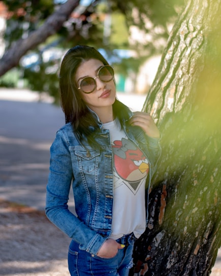 A relaxed model wearing a soft, breathable t-shirt and jeans, standing in a sunlit urban park.