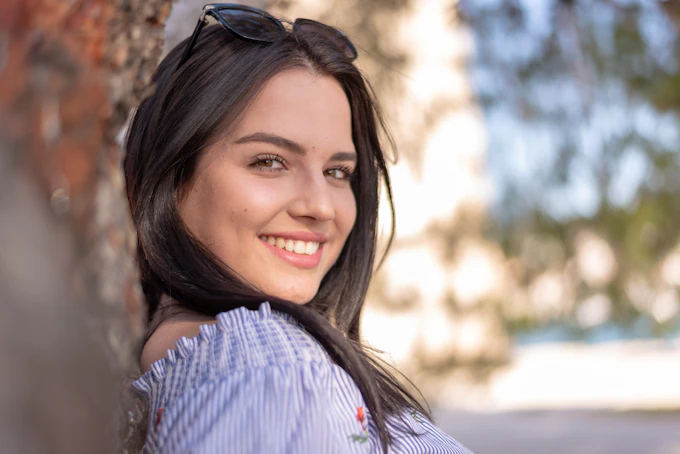 smiling woman in striped shirt wearing black sunglasses